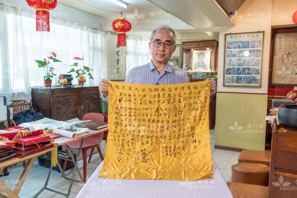 陳天勛居士手持的是福慧精舍落成佛像開光典禮的嘉賓簽到，上面清晰可見香港佛教界多位德高望重的高僧及護法居士的簽名。（梁生庚攝）
